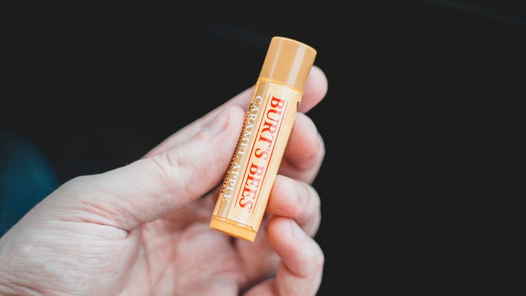 Photograph Of Hand Holding Tube Of Lip Balm