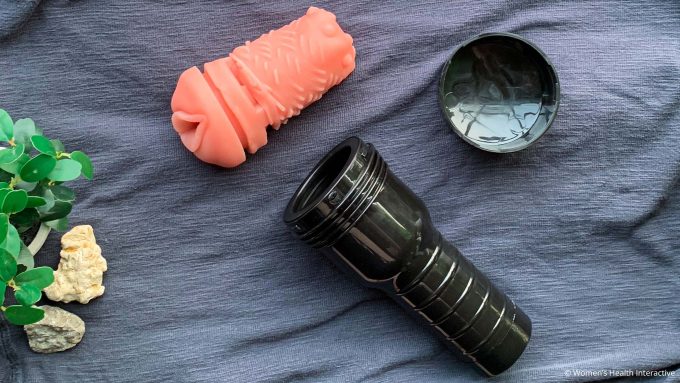 aerial photograph of a fleshlight sleeve removed from its case to display its materials against a dark grey background