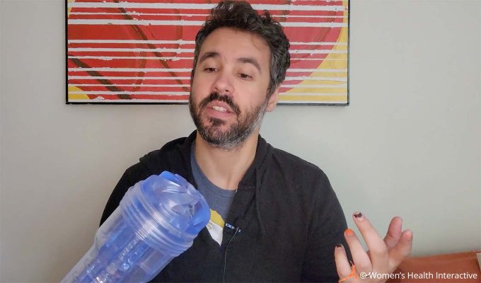photograph of product tester justin holding the clear transparent fleshlight turbo thrust while looking at its orifice closely