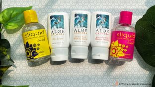 photograph of several bottles of flavored aloe cadabra and sliquid swirl lubricants on a patterned background with plants