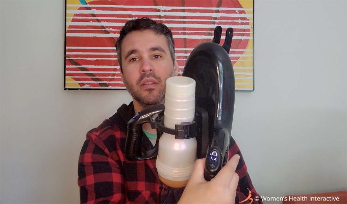 photograph of product tester justin holding the fleshlight universal launch automatic masturbator with a pornstar full-sized fleshlight girl stroker attached to display the entire unit and how it fits together