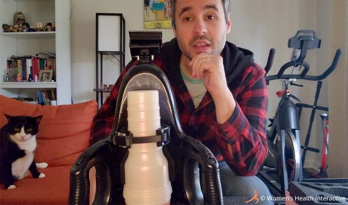 photograph of product tester justin with a curious expression on his face as he sits behind the fleshlight universal launch loaded with a white-cased fleshlight